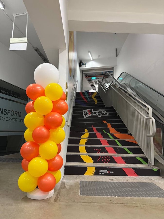Orange, yellow and white balloon column beside a staircase