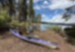 touring kayak next to alpine lake