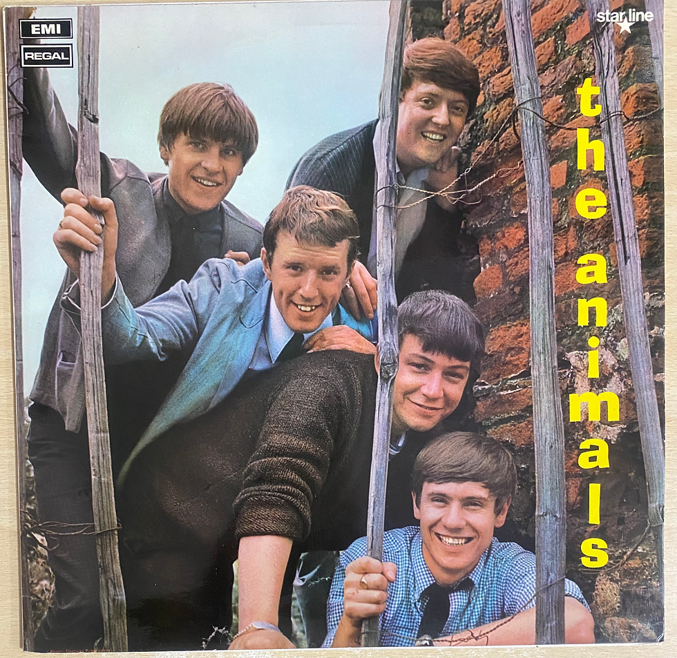 Copertina del disco The Animals: i membri della band sorridono vicino a un muro di mattoni