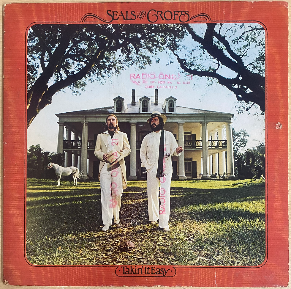 Copertina Seals & Crofts "Uncorked": due uomini in bianco davanti a una villa
