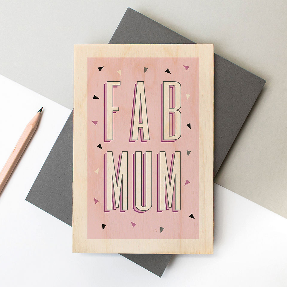 A wooden postcard or keepsake greeting card made from birch plywood with a pink design that reads 'Fab Mum'. Perfect for Mother's Day. Comes with a grey envelope.