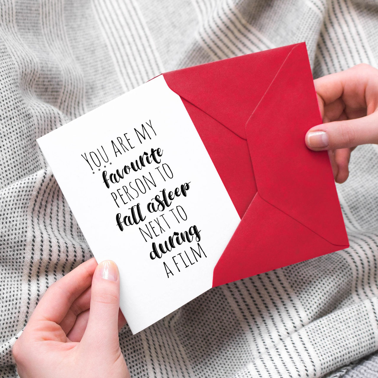 A monochrome anniversary card with a funny quote about falling asleep during a film. Paired with a red envelope.