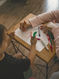 A child sat with a teacher writing their name in colourful crayons.