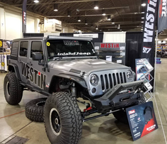Gray "WESTIN" Jeep Wrangler, "InlandJeep" banner, at auto show.