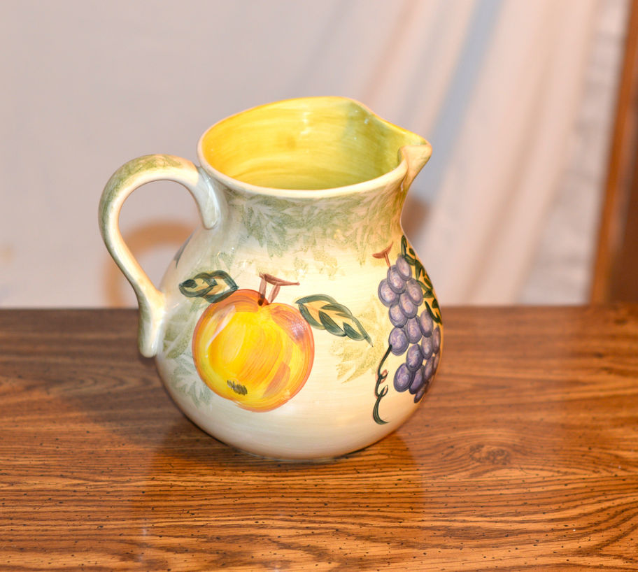 Beautiful mixed fruit pitcher is hand painted and hand crafted vibrant depictions of grapes, pear, and peach fruits