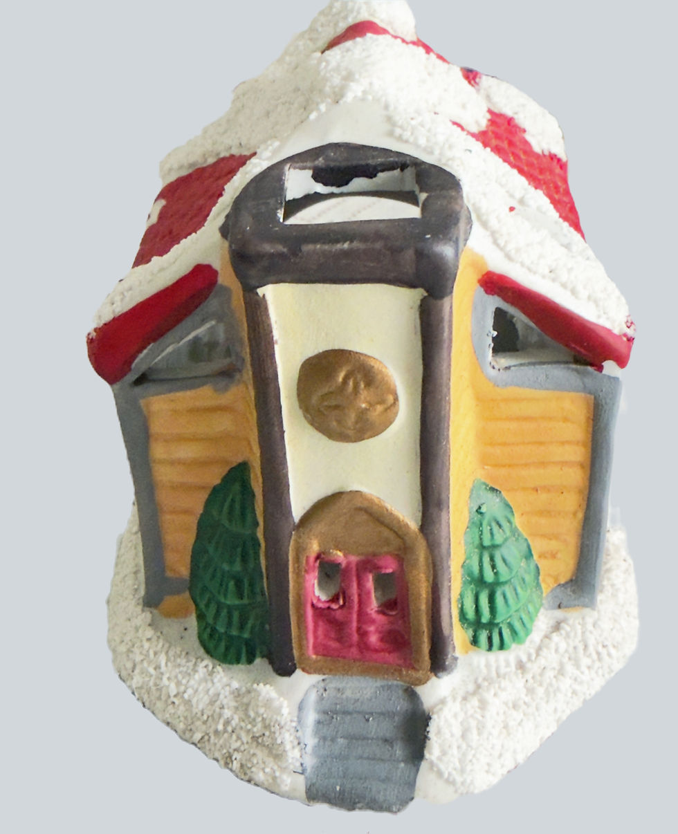 Front entrance of a vintage hand painted ceramic holiday chapel candle holder with red double doors.