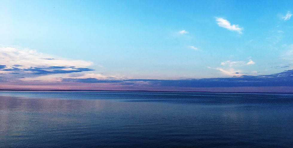 An image of Cold Lake at dusk, with some clouds near the horizon.