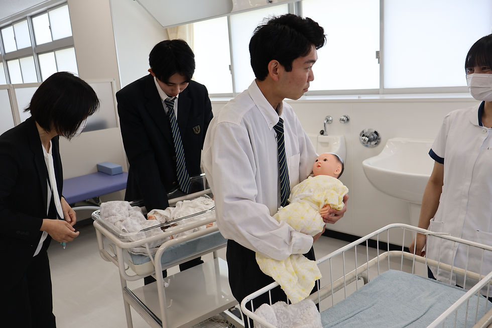 最後に、実習室でガウンの着方・脱ぎ方と新生児の抱っこ体験を行いました。