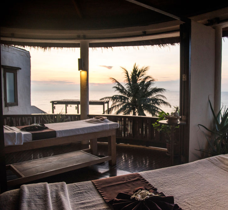 Open-air spa with massage tables and ocean views at sunset on a women's retreat in Costa Rica