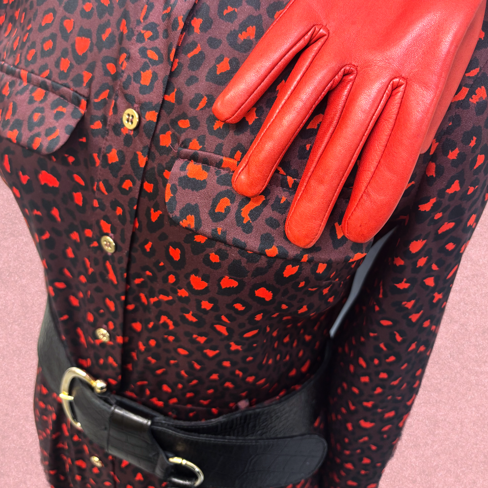 Maroon leopard print dress with red leather gloves and a black leather belt and golden buckle.