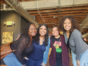 four women standing together smiling