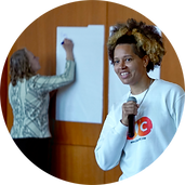 An educator writes on a flip chart as Genesis Be, Moral Courage Global Ambassador, leads an interactive film screening.