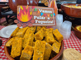 Mesa decorada com comidas típicas de festa junina servidas em buffet a domicílio