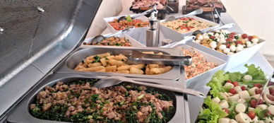Buffet a domicílio com carnes grelhadas e acompanhamentos servidos em ambiente residencial