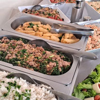 Mesa de saladas e guarnições variadas servidas em buffet a domicílio para churrasco
