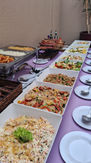 Buffet de churrasco com carnes assadas e variedade de saladas frescas servido em domicílio