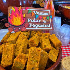 Mesa decorada com comidas típicas de festa junina servidas em buffet a domicílio