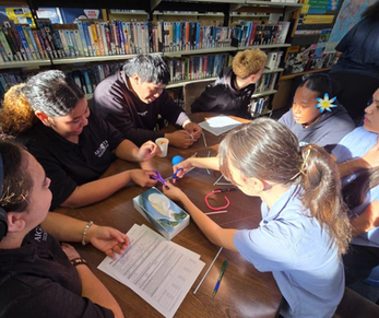 Group of secondary school students sitting together and smiling during Puatala programme