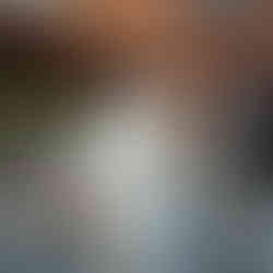 A bride in a flowing white coat and groom walking together down a historic street in Roskilde.