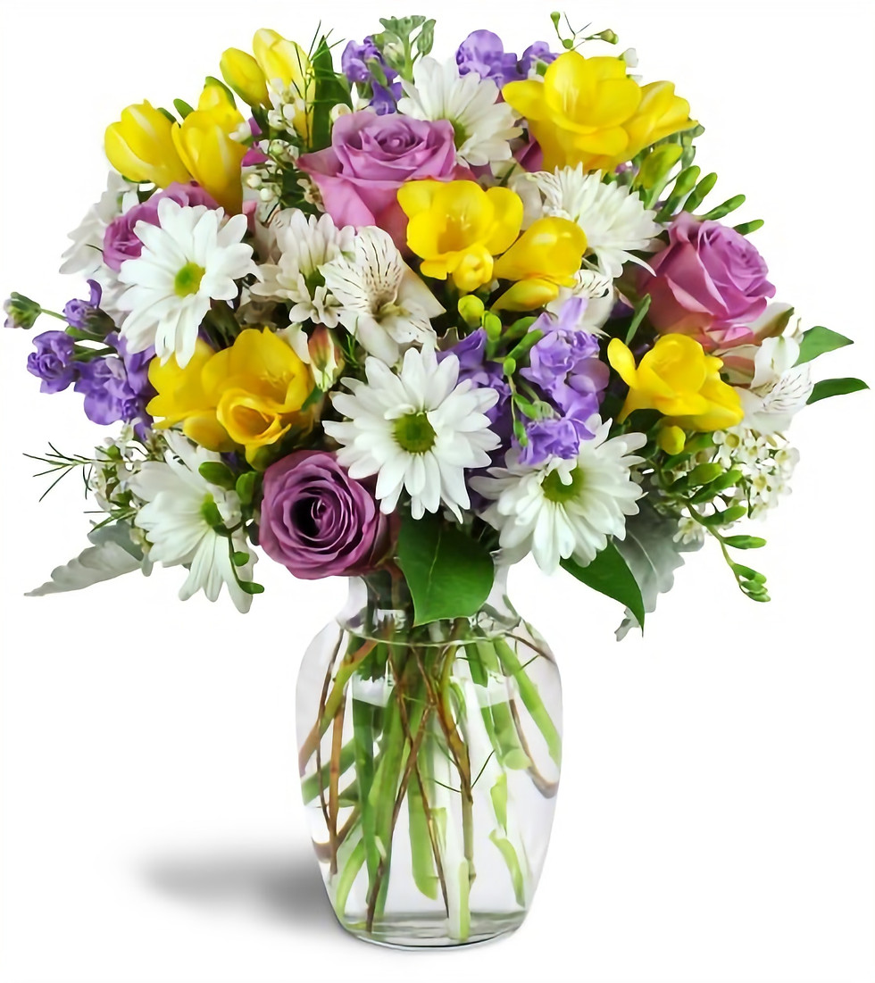 A selection of bright mix sunshiny cut flowers arranged in a glass vase.