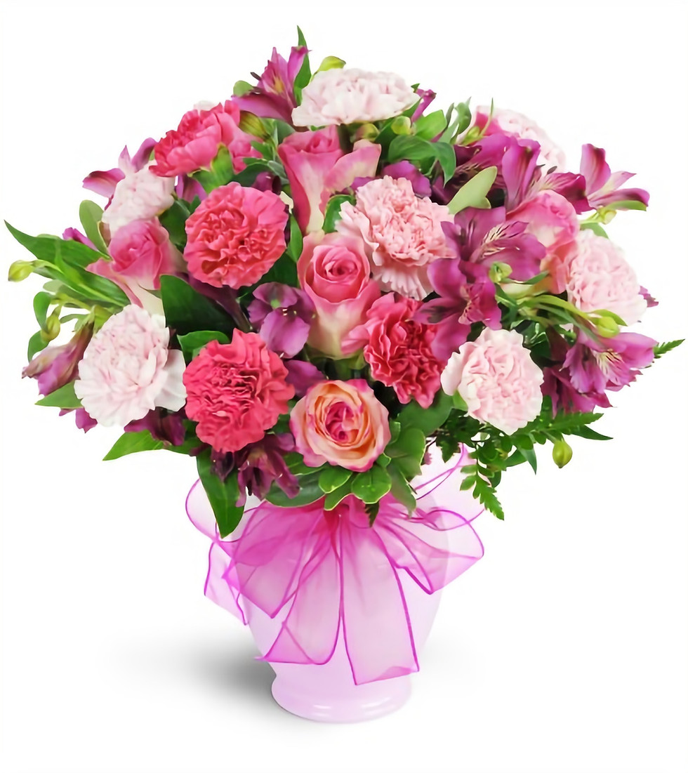 A selection of bright coloured Pink Roses and Carnations arranged in a Vase.