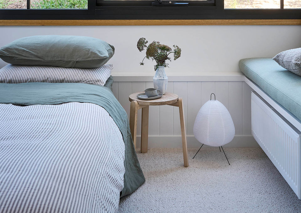 Bedroom with a large window overlooking a wooded area