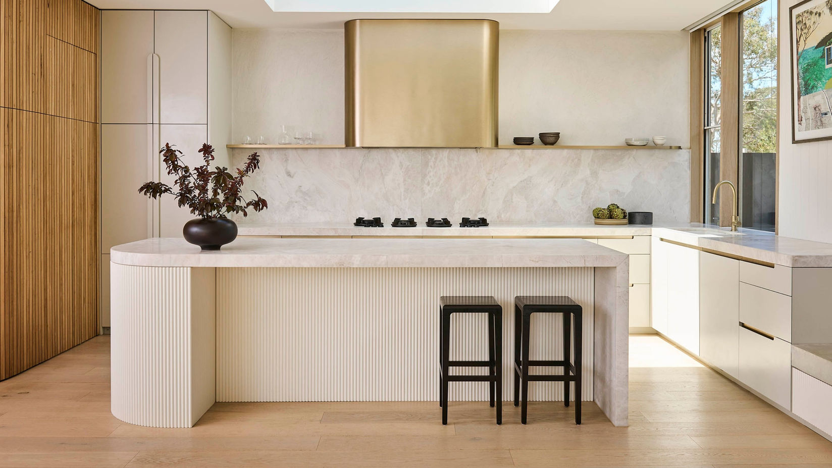 Modern kitchen with white cabinets, a large island, and two black bar stools