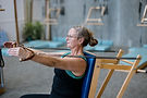 Woman using Pilates equipment, doing arm exercises in a studio,.