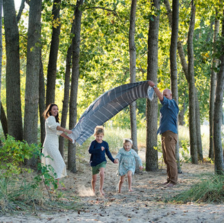Family at mini session at the beach running under blanket