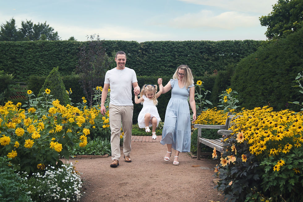 Family at custom session at Chicago Botanic Gardens. Parents swinging young daughter
