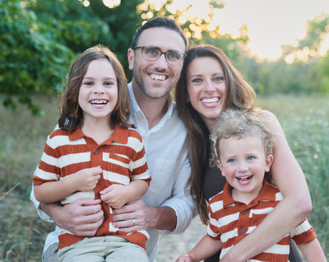 Family with young kids laughing at the beach 