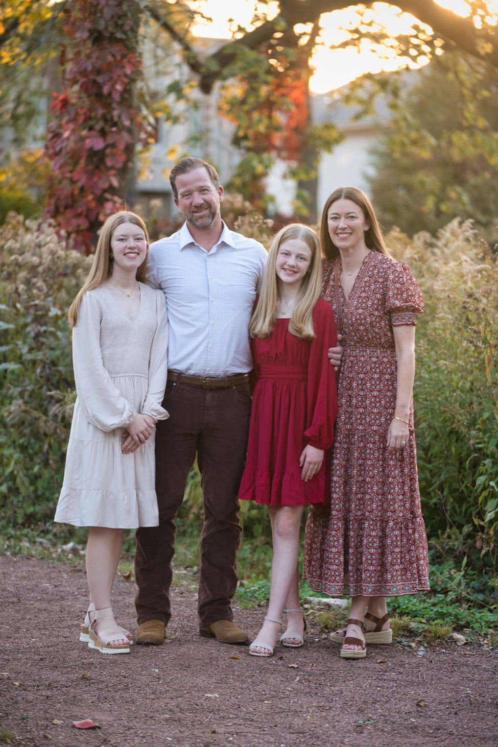 Family picture in fall with mom, dad and two middle school age girls. 