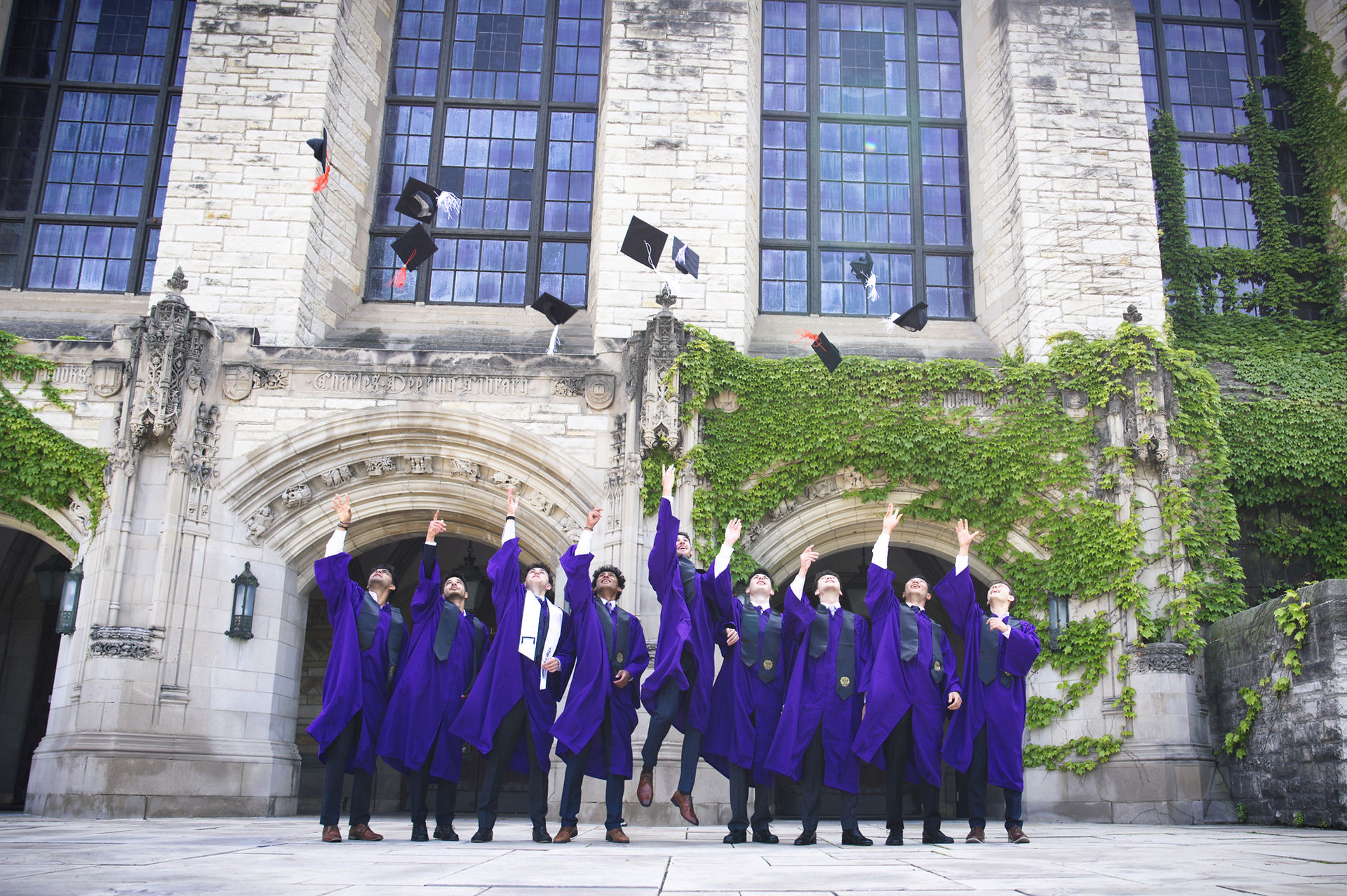 Group graduation cap toss Northwestern University Deering Library — graduation photographer Evanston Chicago North Shore
