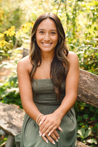 Portrait of a Young Woman sitting on a rustic bench in a wildflower garden