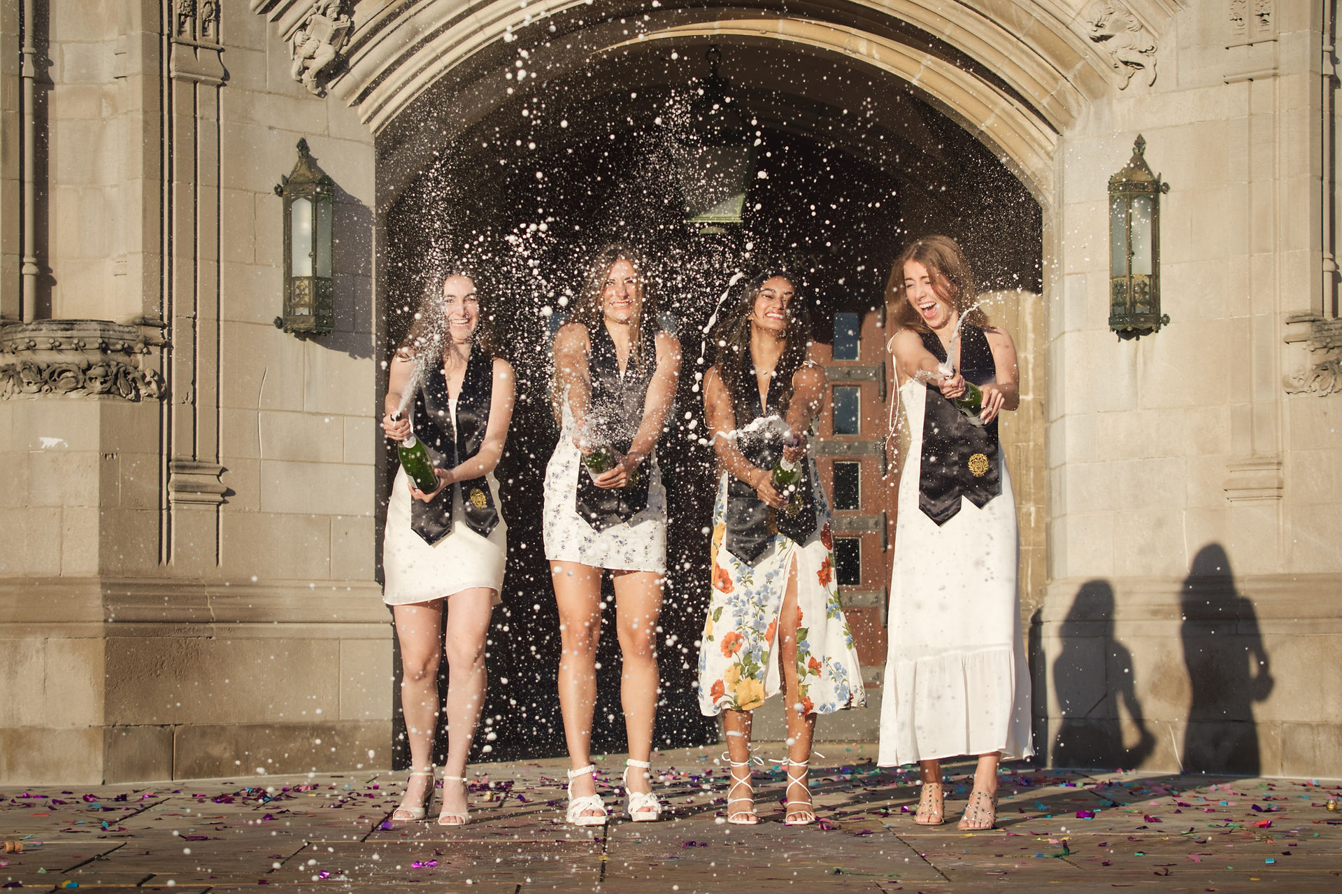 Northwestern University graduation friend group champagne celebration at campus arch — group graduation photographer Evanston Illinois