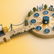 Illustration showing a small health technology supplier connecting into a wider NHS interoperability ecosystem. A laptop and product icon sit on a small platform linked by a puzzle-piece bridge to a larger healthcare network containing hospitals, community services, clinical systems and shared data resources. The scene uses amber and teal colours to represent the journey from a supplier product to connected NHS services.
