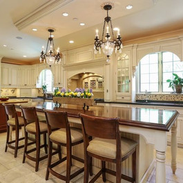 Two Chefs kitchen with traditional cabinetry and details, double island workspace, farmsink and intricate mosaic backsplash.
