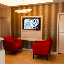 Custom reception light wood and textured acrylic desk accommodates the work flow, privacy and storage for the receptionist and offers a more comfortable and informative wait space for guests.