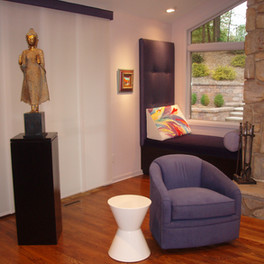 Custom window seats flank large stone fireplace in contemporary family room.