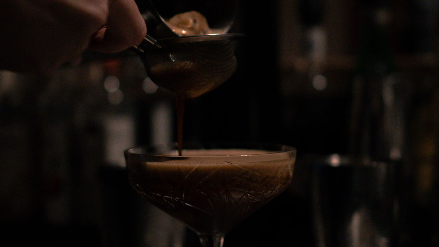 Ein Barkeeper gießt Espresso in einen Cocktailglas - Referenzbild Arbeit für einen Kunden