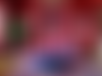 Decoração maximalista curada 2026: sala com mix de cores vibrantes e texturas. Destaque para o sofá de veludo rosa, almofadas estampadas e quadros de arte contemporânea da coleção Melissa Pozzi Arts em parede vermelha