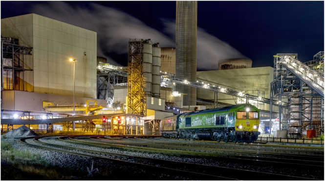 Eddie Holden is a Railway Photographer and has a website called eddieholden.net this is a Class 66 in green livery at night in drax power station. The class 66 is called climate hero.