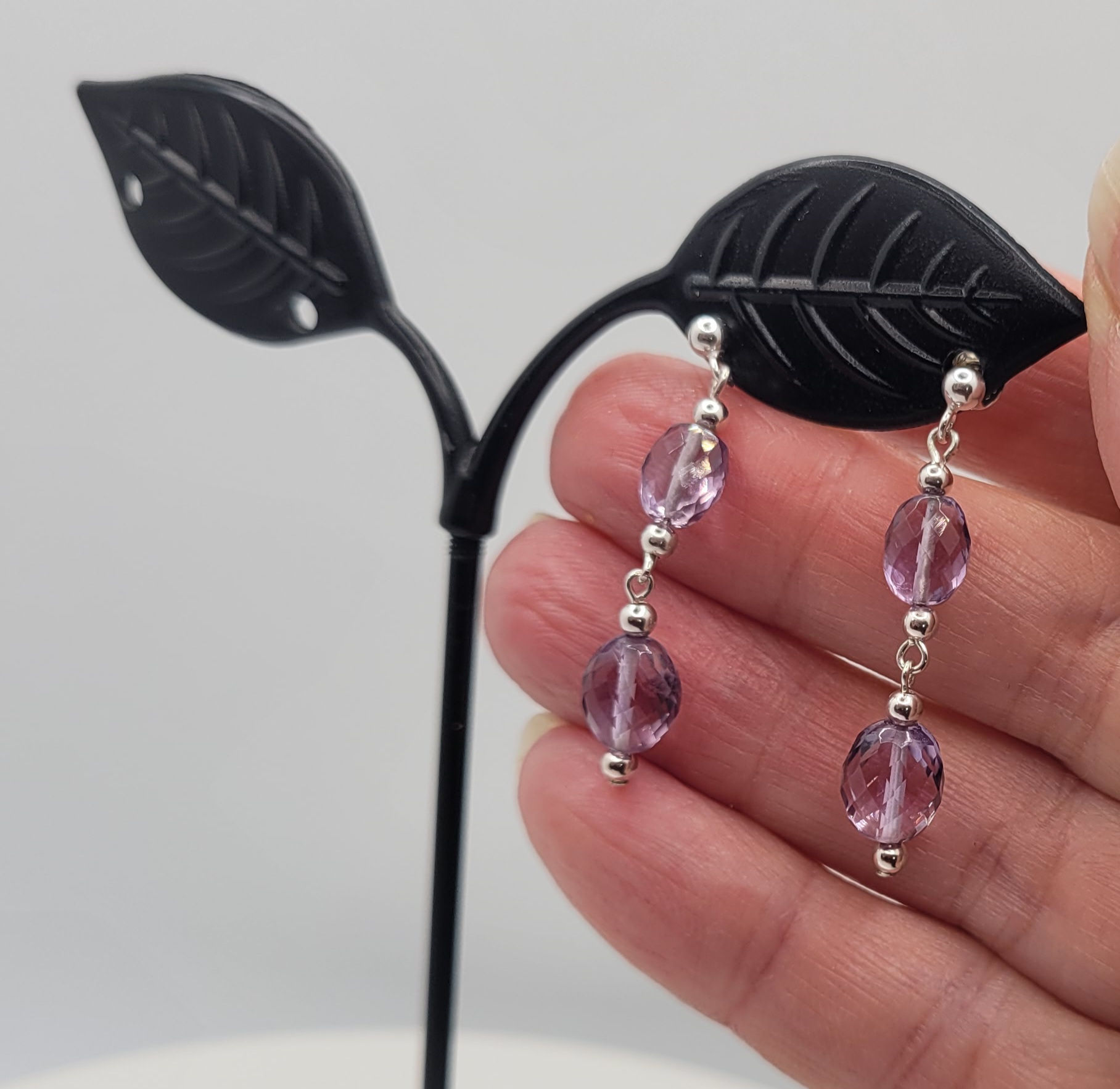 Amethyst and sterling silver drop earrings on black display stand