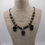 Thumbnail: Beaded necklace on cord with 3 Arfvedsonite charms, displayed on grey necklace bust