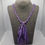 Thumbnail: Purple plaited sari silk necklace with matching tassel and charoite beads at the front. Displayed on a grey necklace bust.