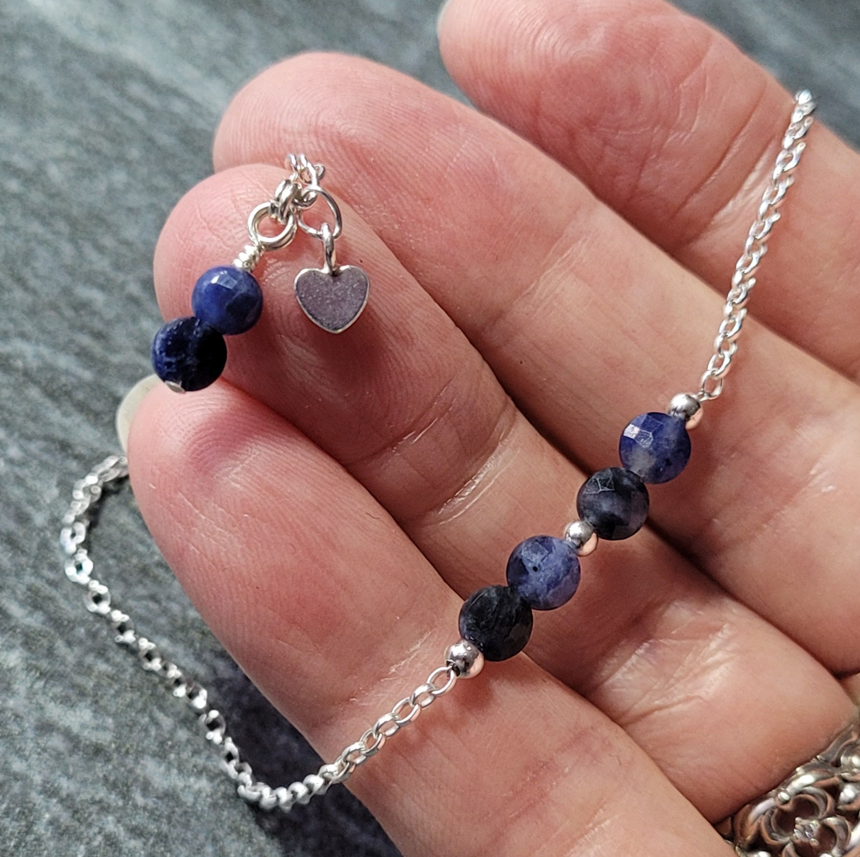 Sodalite and sterling silver anklet, displayed in hand