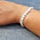 Thumbnail: Keshi cultured pearl bracelet with sterling silver angel wing charm displayed on wrist