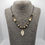 Thumbnail: Beaded necklace with agate pendant, displayed on grey necklace bust