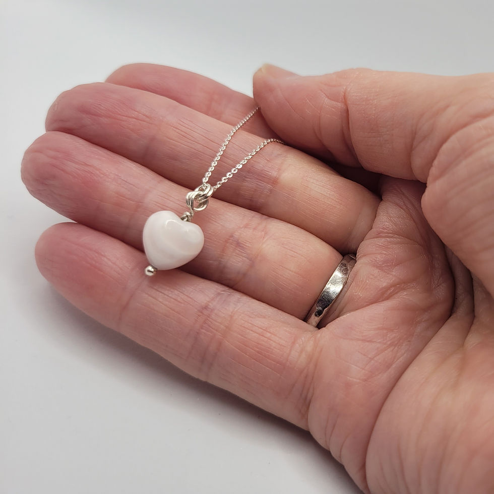 Thumbnail: Mangano calcite pendant on sterling silver chain, displayed in hand