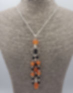 Carnelian and black spinel pendant on sterling silver chain, displayed on grey necklace bust